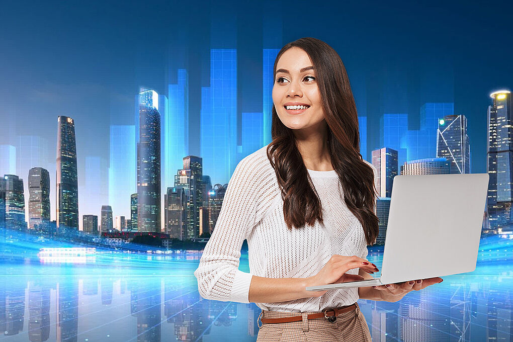 Frau mit Laptop vor Skyline bei Nacht